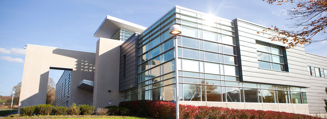 TCCC A shiny glass building reflecting sun off its windows.